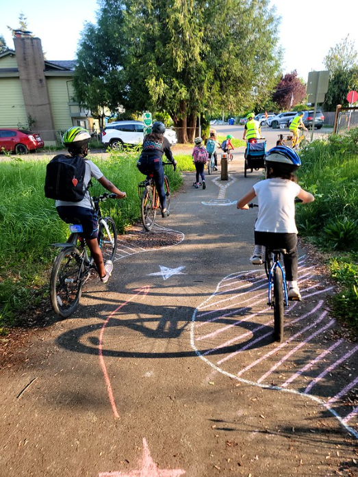 a group of students bike on a trail